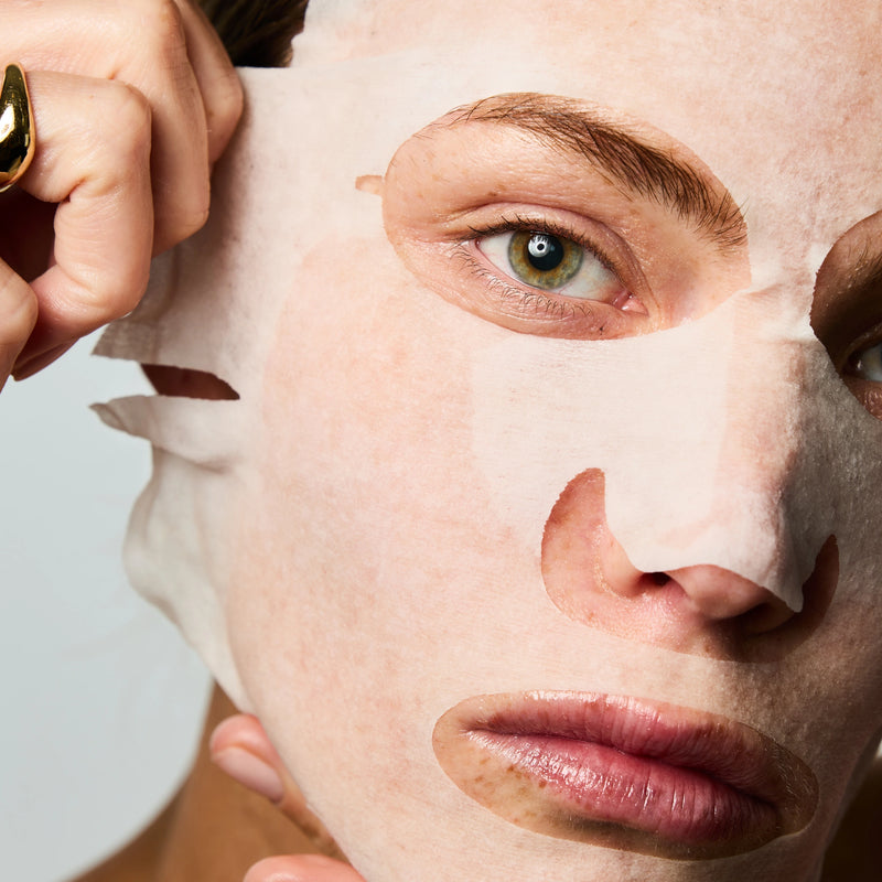 Femme retirant son masque tissu posé sur son visage.