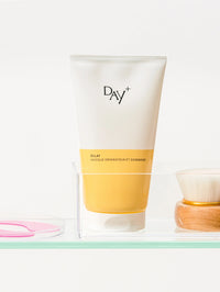 Tube du Masque Réparateur & Gommage posé sur une étaggère aux côtés d'autres produits skincare.