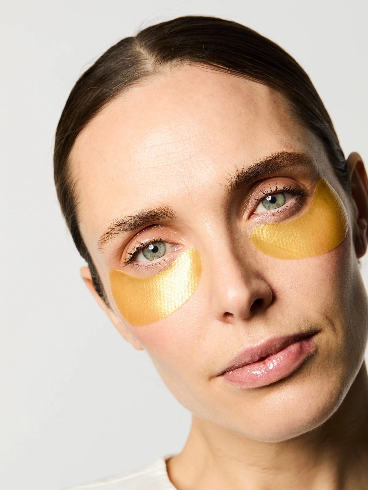 Routine de soin avec les Patchs Anti-âge de couleur jaune irisé.