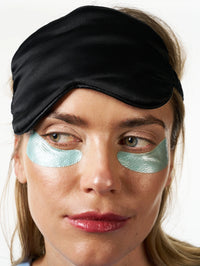 Femme portant les Patchs Yeux Régénérants Nuit portant un masque de nuit sur le front.