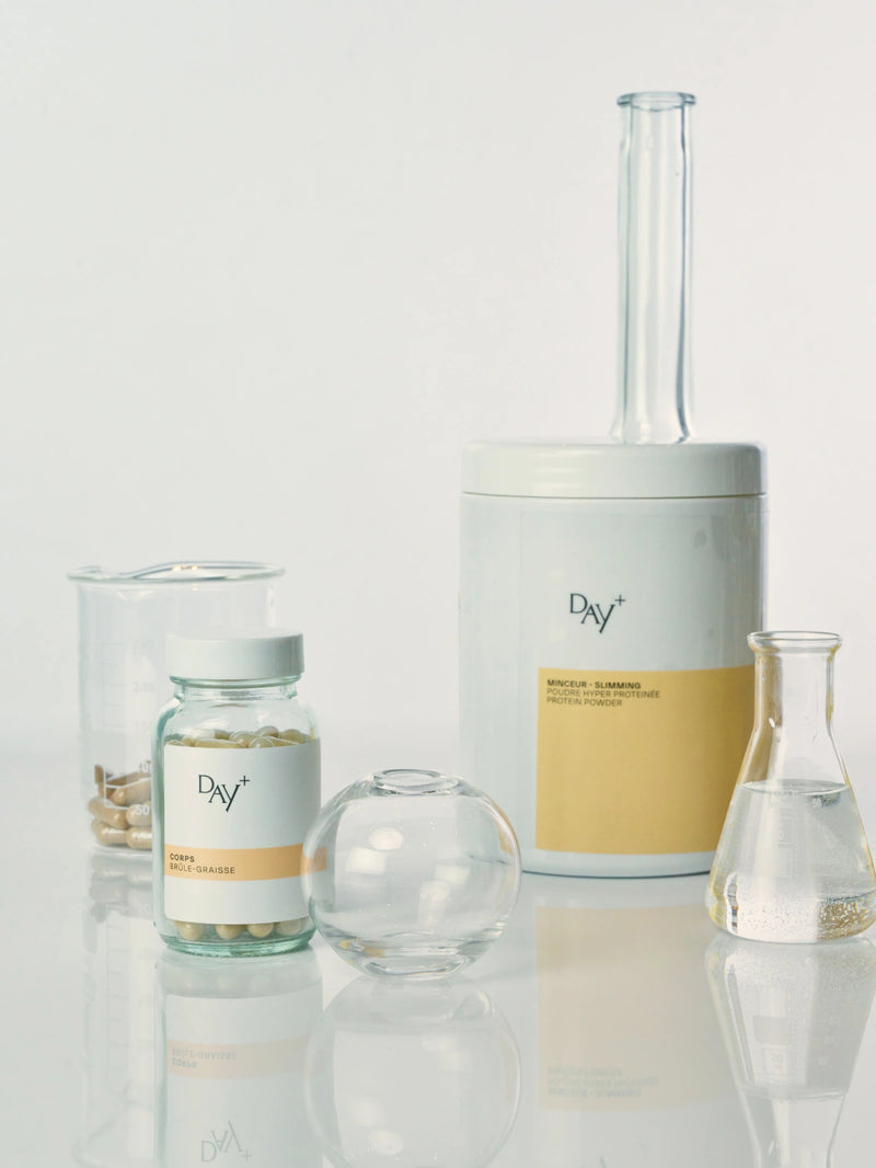 2 compléments alimentaires minceur sur une table de laboratoire : le Poudre Hyperprotéinée et les Gélules Brûle-Graisses.