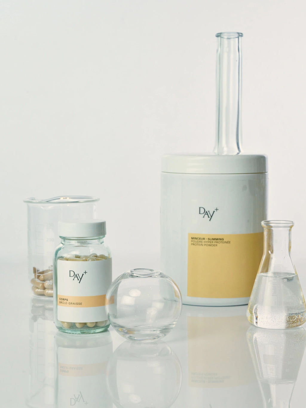 2 compléments alimentaires minceur sur une table de laboratoire : le Poudre Hyperprotéinée et les Gélules Brûle-Graisses.