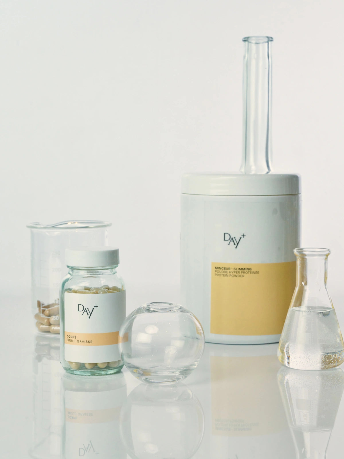 2 compléments alimentaires minceur sur une table de laboratoire : le Poudre Hyperprotéinée et les Gélules Brûle-Graisses.