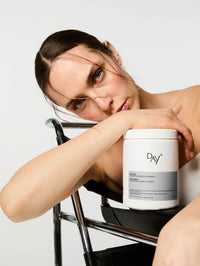 Femme accoudée à la Poudre Collagène & Vitamines+ en édition silver.