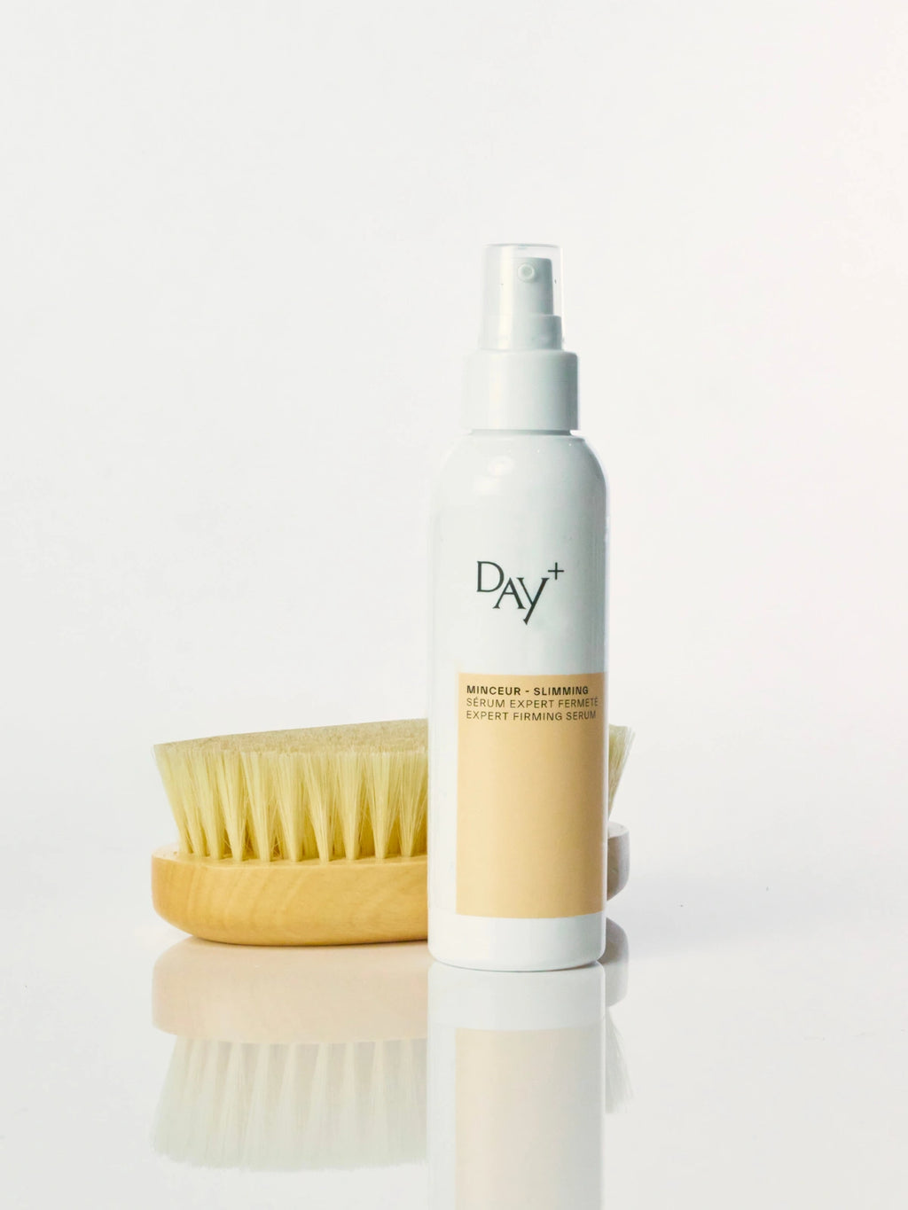 Le sérum minceur Expert Fermeté à côté de la Brosse Crops Day+ pour une routine de soins corps complète.