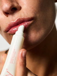 Femme s'appliquant le Sérum Lèvres Repulpant SPF 30 en teinte 01. Clear Gloss.