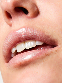 Focus sur la texture et le fini du Sérum Lèvres Repulpant SPF 30 en teinte 03. Glitter All Over sur les lèvres.