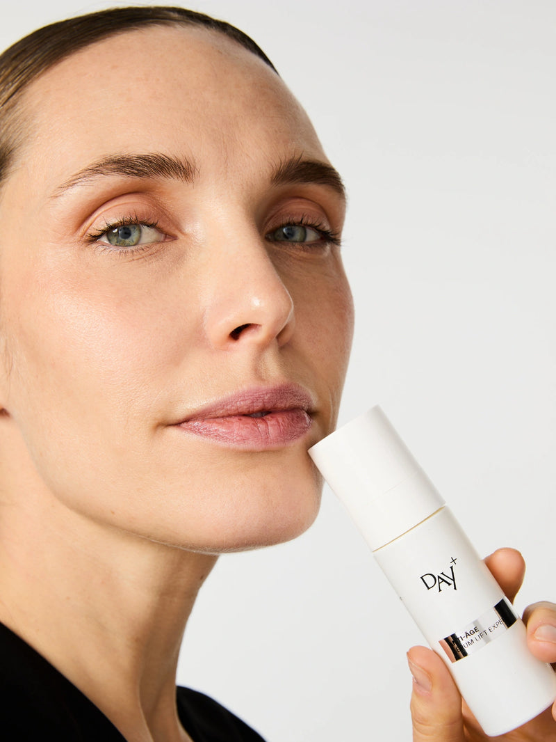 Femme avec le Sérum anti-âge Lift Expert près de son visage.