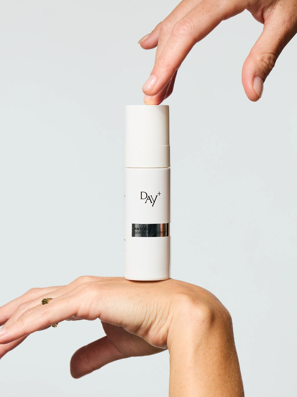 Le Sérum Anti-âge Lift Expert tenu délicatement dans les mains d'une femme.