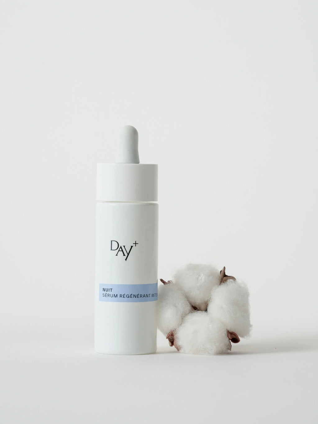 Le Serum Nuit Régénérant Intense à côté d'une fleur de coton.