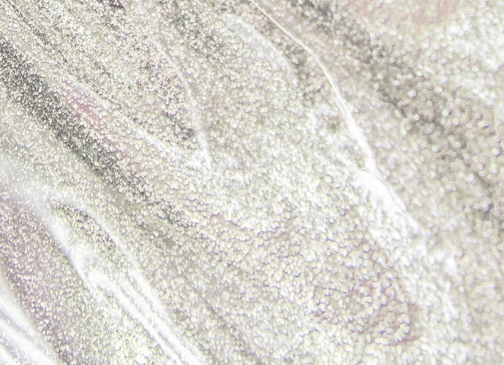 Zoom sur la texture transparente parsemée de nacre du Sérum Lèvres en teinte 03. Glitter All Over.