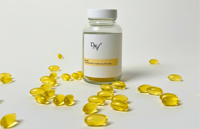 Pilulier de Soin Concentré Hydra-Nutrition avec de nombreuses capsules autour.
