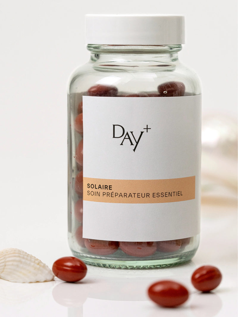 Pilulier du Soin Préparateur Essentiel avec quelques gélules rouges autour.