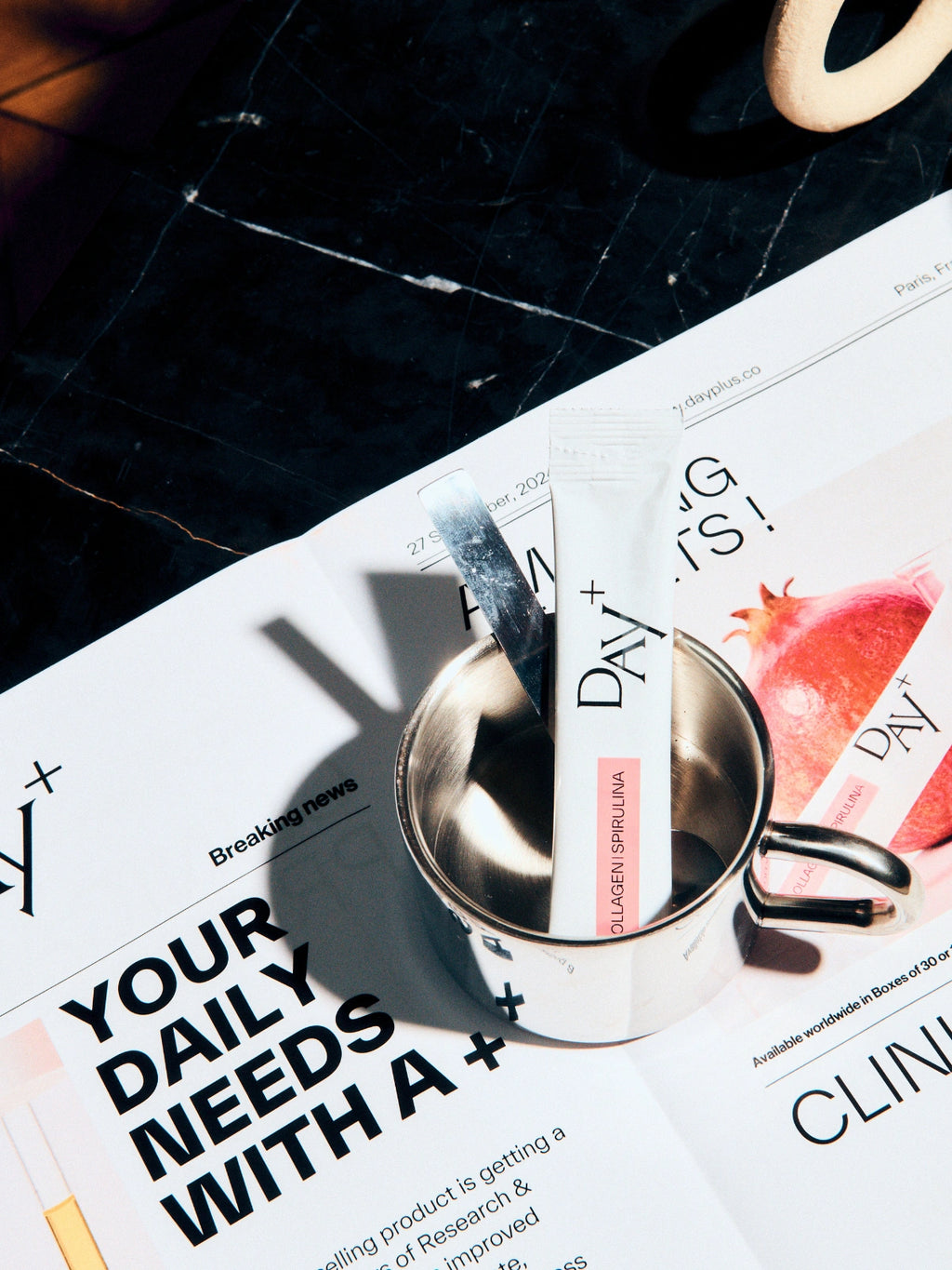 Un stick au collagène à boire posé sur un magazine Day+ sur l'étude clinique de ce produit.