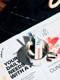 Un stick au collagène à boire posé sur un magazine Day+ sur l'étude clinique de ce produit.