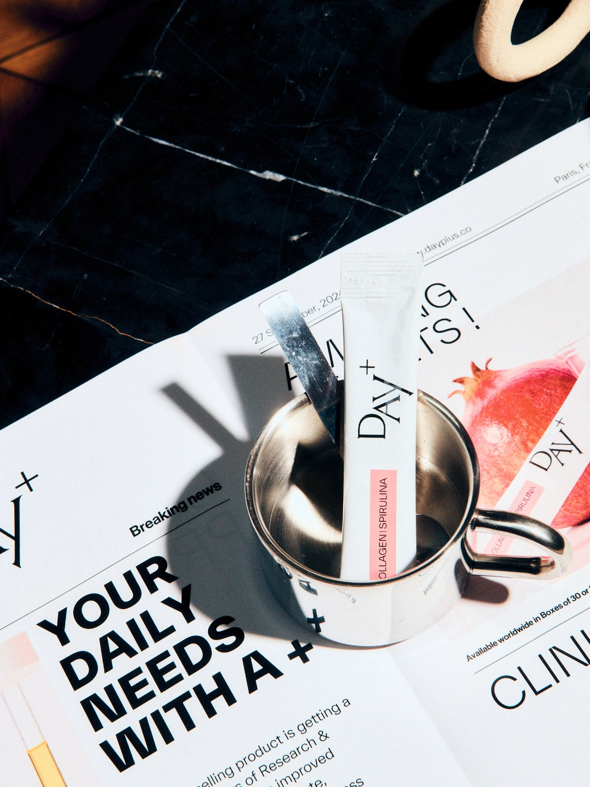 Un stick au collagène à boire posé sur un magazine Day+ sur l'étude clinique de ce produit.