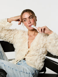 Femme assise sur une chaise prenant son stick au collagène à boire.