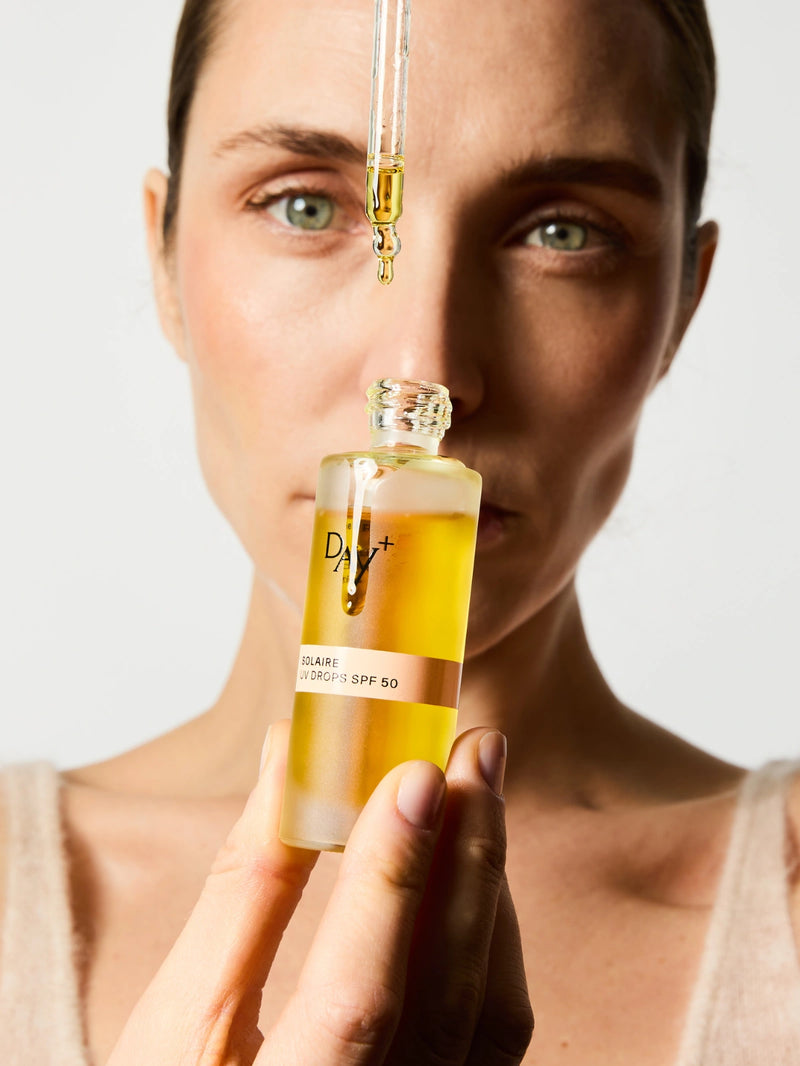 Femme qui fait couler le Sérum UV Drops SPF 50