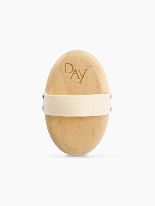 Brosse Corps avec logo Day+ et lanière beige pour faciliter sa prise en main.