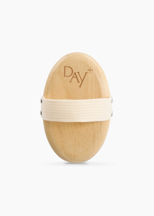 Brosse Corps avec logo Day+ et lanière beige pour faciliter sa prise en main.