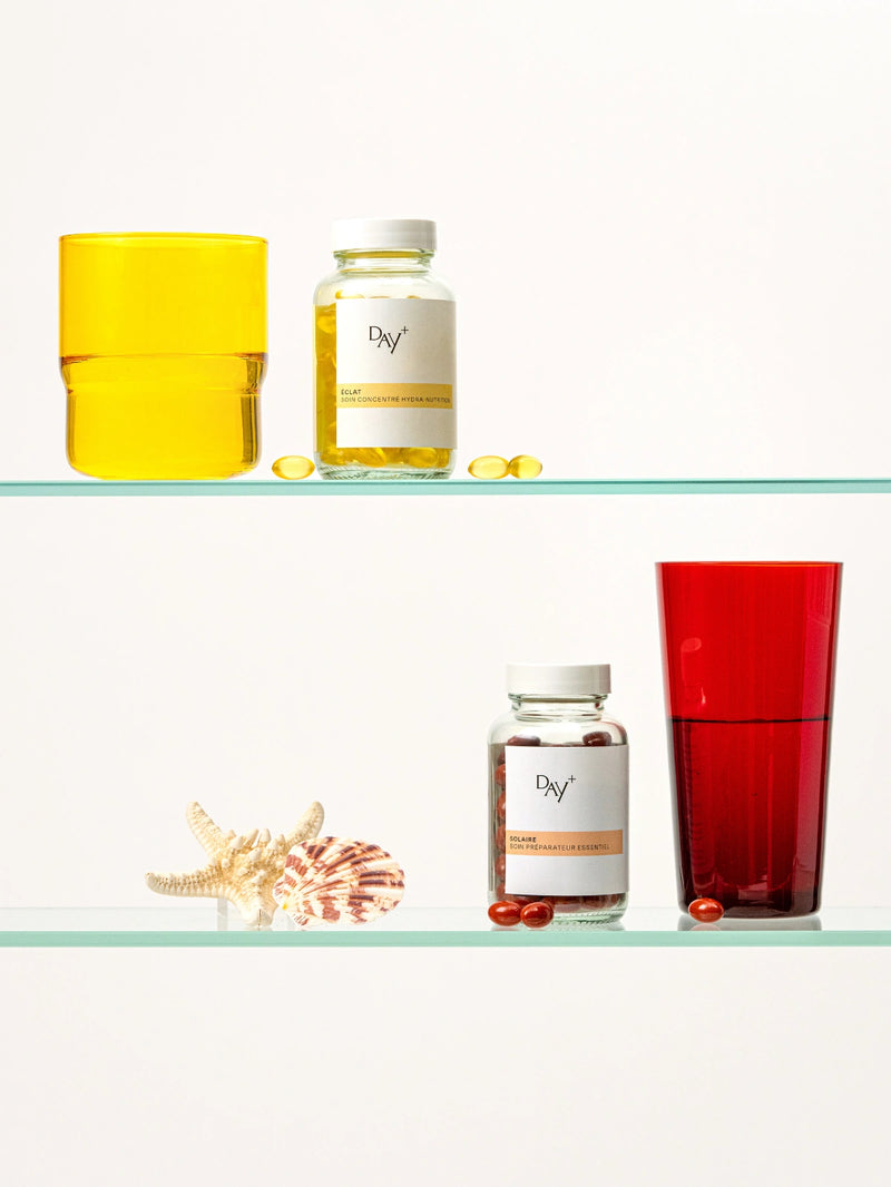 Piluliers de Soin Concentré Hydra-Nutrition et de Soin Préparateur Essentiel sur l'étagère d'une salle de bain.