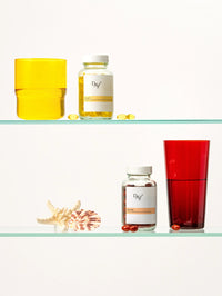 Piluliers de Soin Concentré Hydra-Nutrition et de Soin Préparateur Essentiel sur l'étagère d'une salle de bain.