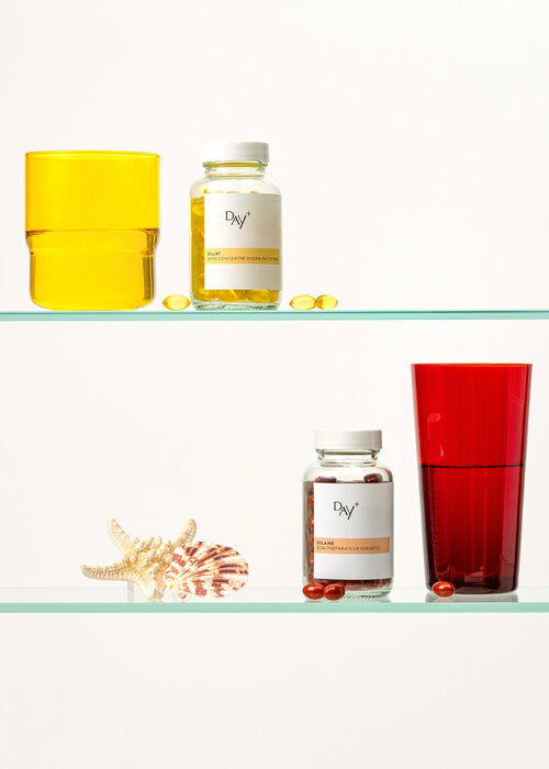 Piluliers de Soin Concentré Hydra-Nutrition et de Soin Préparateur Essentiel sur l'étagère d'une salle de bain.