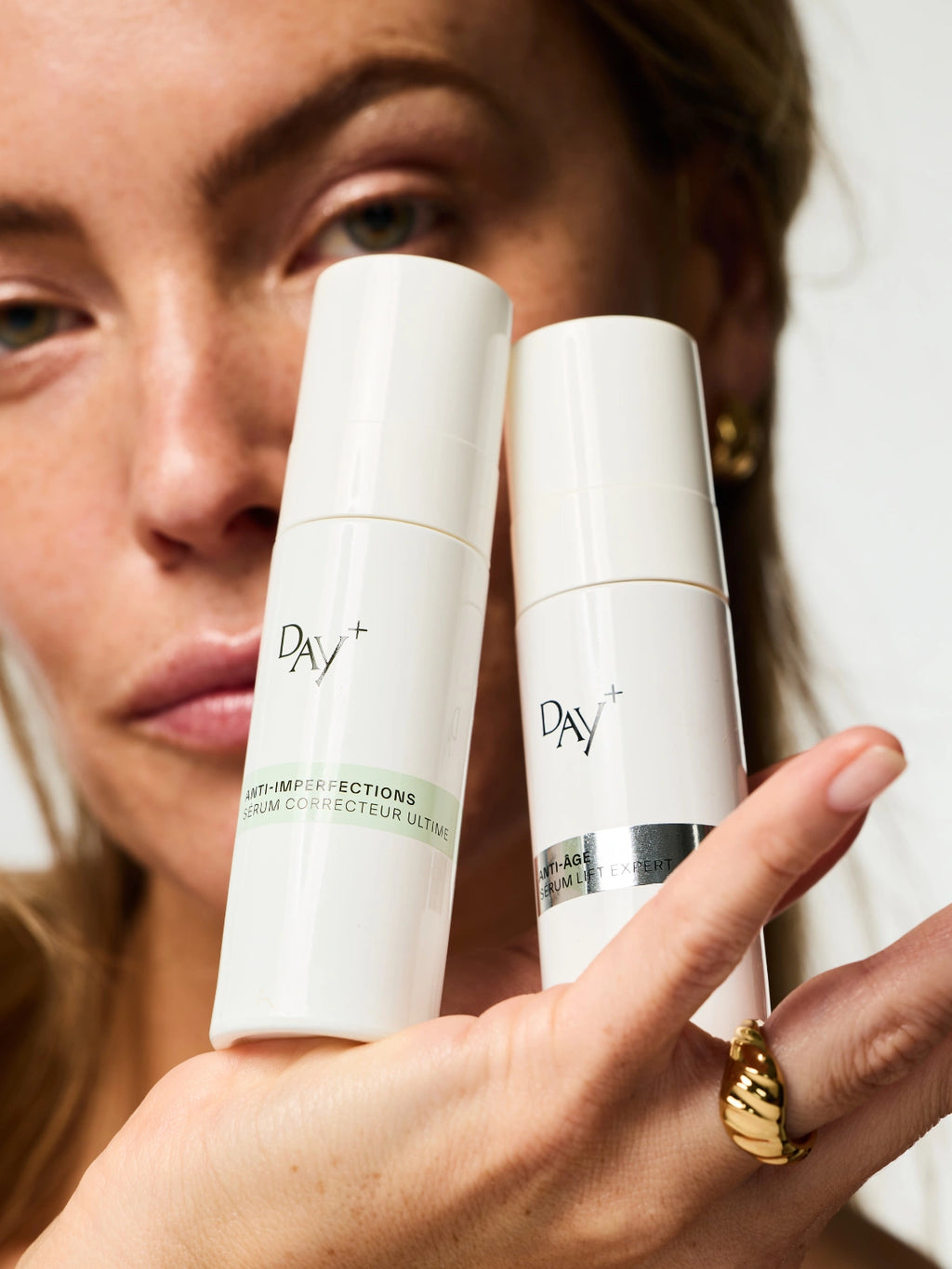 Femme tenant dans sa main le Duo de Sérums Experts : le Sérum Anti-imperfections Correcteur Ultime et le Sérum Anti-âge Lift Expert.