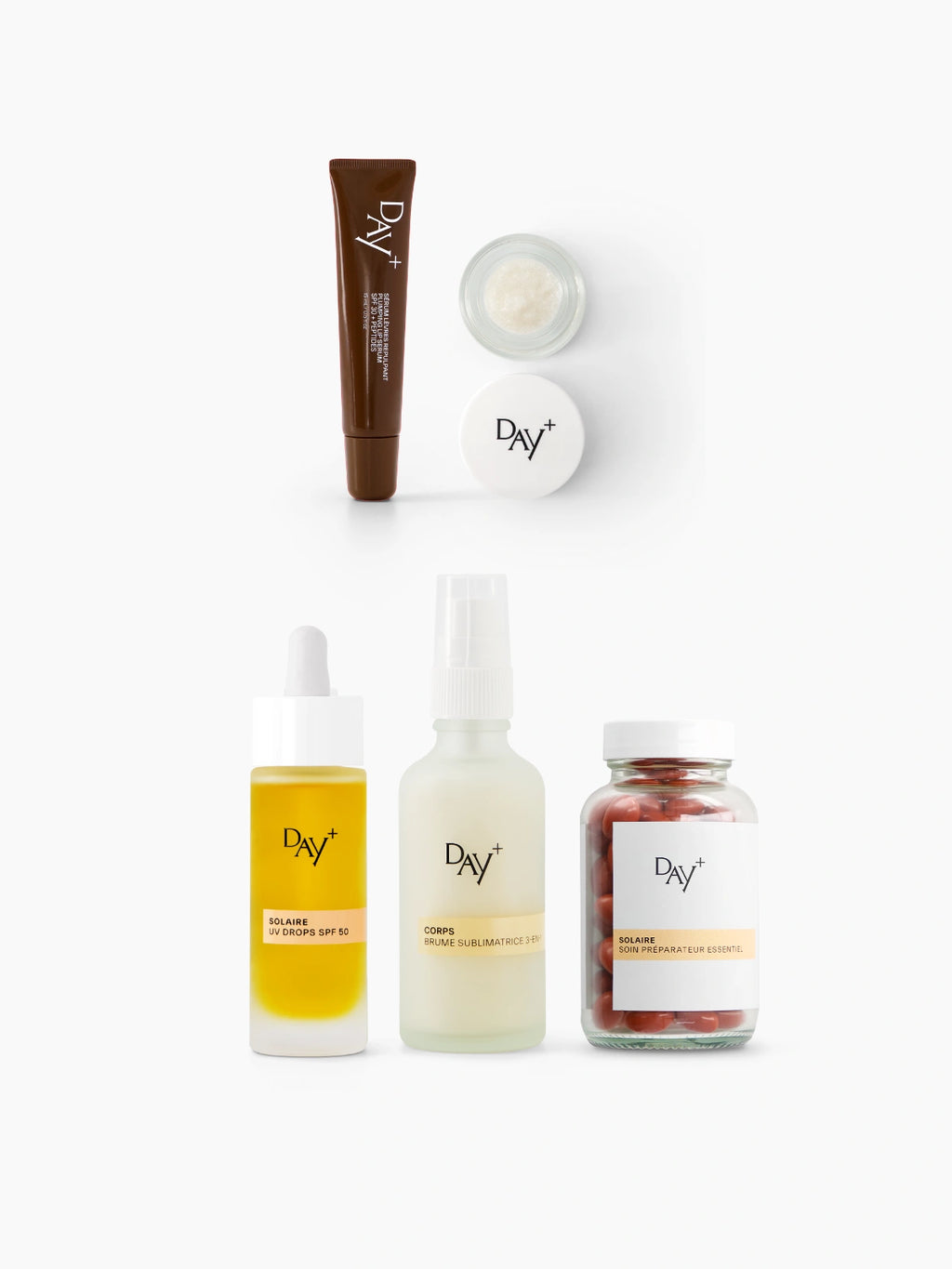 Présentation packshot des produits présents dans le coffret "Essentiels de l'été", composé : d'un Sérum Lèvres Repulpant (Teinte 02. Light Brown), d'un Eyes & Cheeks Gloss, d'un sérum solaire UV Drops SPF 50, d'une Brume Sublimatrice 3-en-1 et d'un complément Préparateur Solaire.