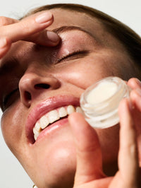 Femme s'appliquant du Eyes & Cheeks Gloss sur la paupière.