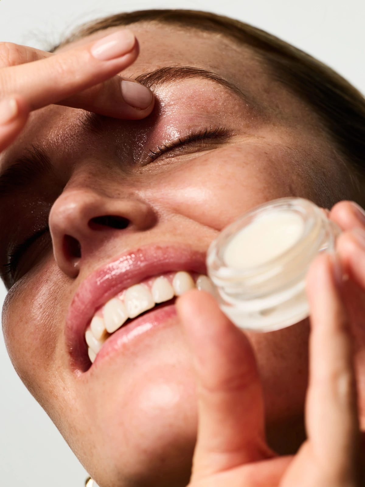 Femme s'appliquant du Eyes & Cheeks Gloss sur la paupière.