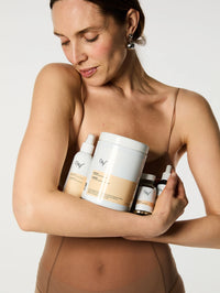 Mannequin avec dans ses bras tous les produits de la collection Minceur : le Sérum Expert Fermeté, la Poudre Hyperprotéinée, les Gélules Brûle-Graisse et l'Élixir Activateur de Métabolisme.