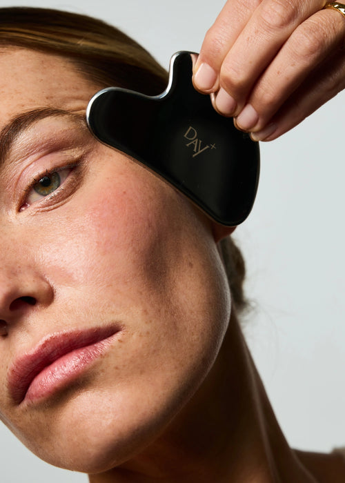 Routine de soin visage à l'aide du Gua Sha Day+ en acier inoxydable.