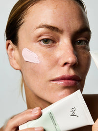 Femme tenant dans sa main un tube du Masque Exfoliant Perfecteur.