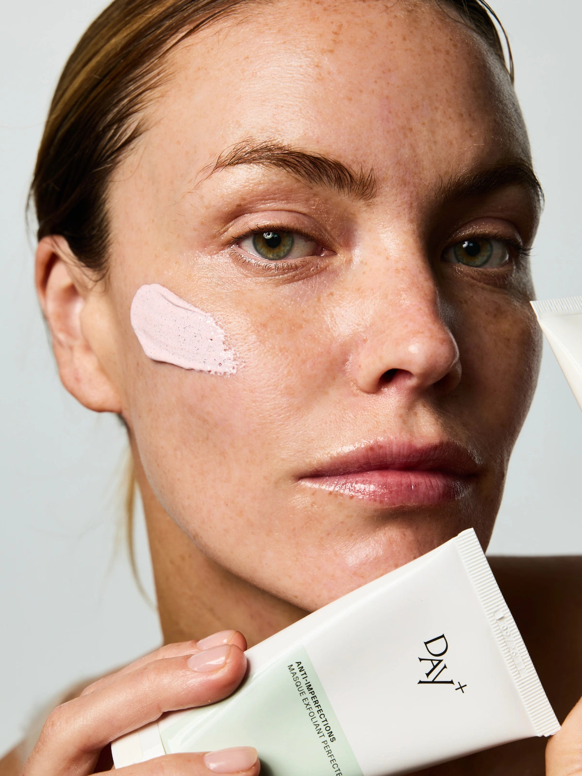 Femme tenant dans sa main un tube du Masque Exfoliant Perfecteur.