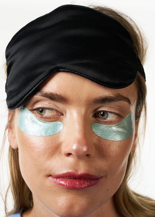 Femme portant les Patchs Yeux Régénérants Nuit portant un masque de nuit sur le front.