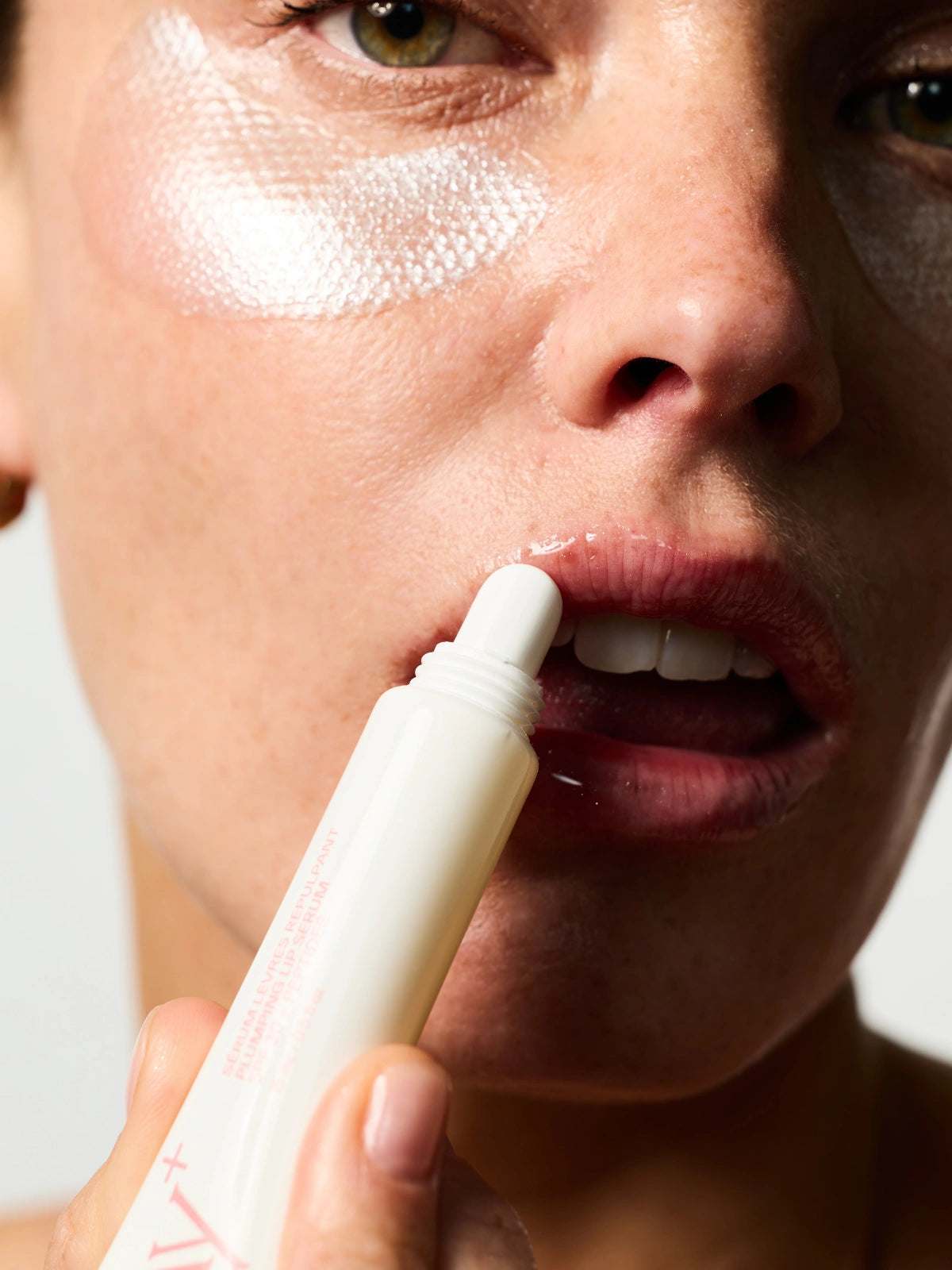 Femme s'appliquant le Sérum Lèvres Repulpant SPF 30 + Peptides en teinte 01. Clear Gloss.