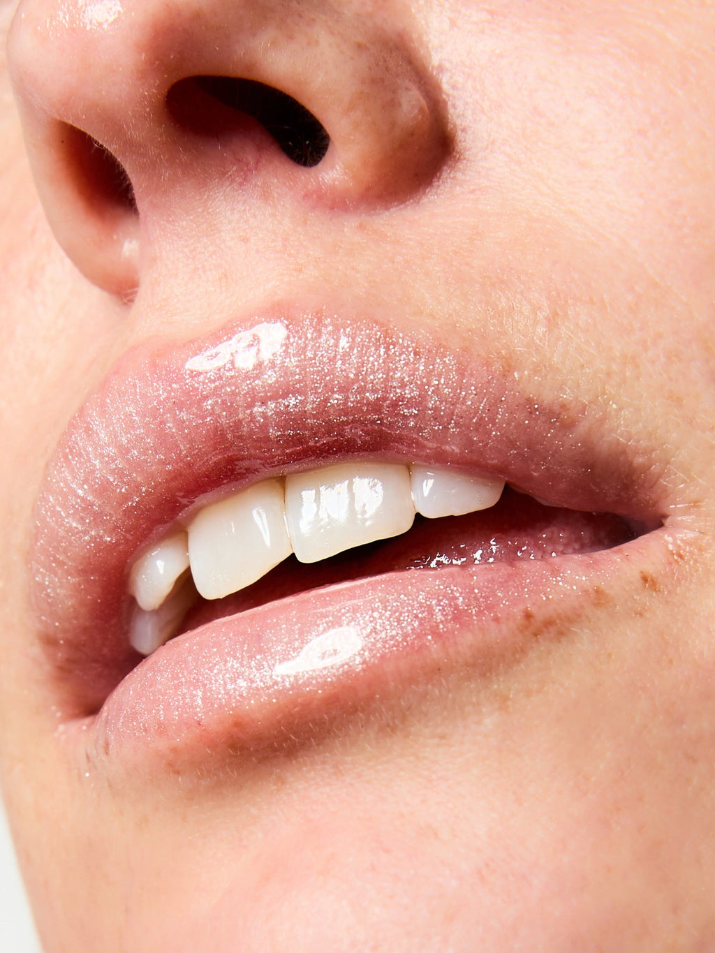 Focus sur la texture et le fini du Sérum Lèvres Repulpant SPF 30 en teinte 03. Glitter All Over sur les lèvres.