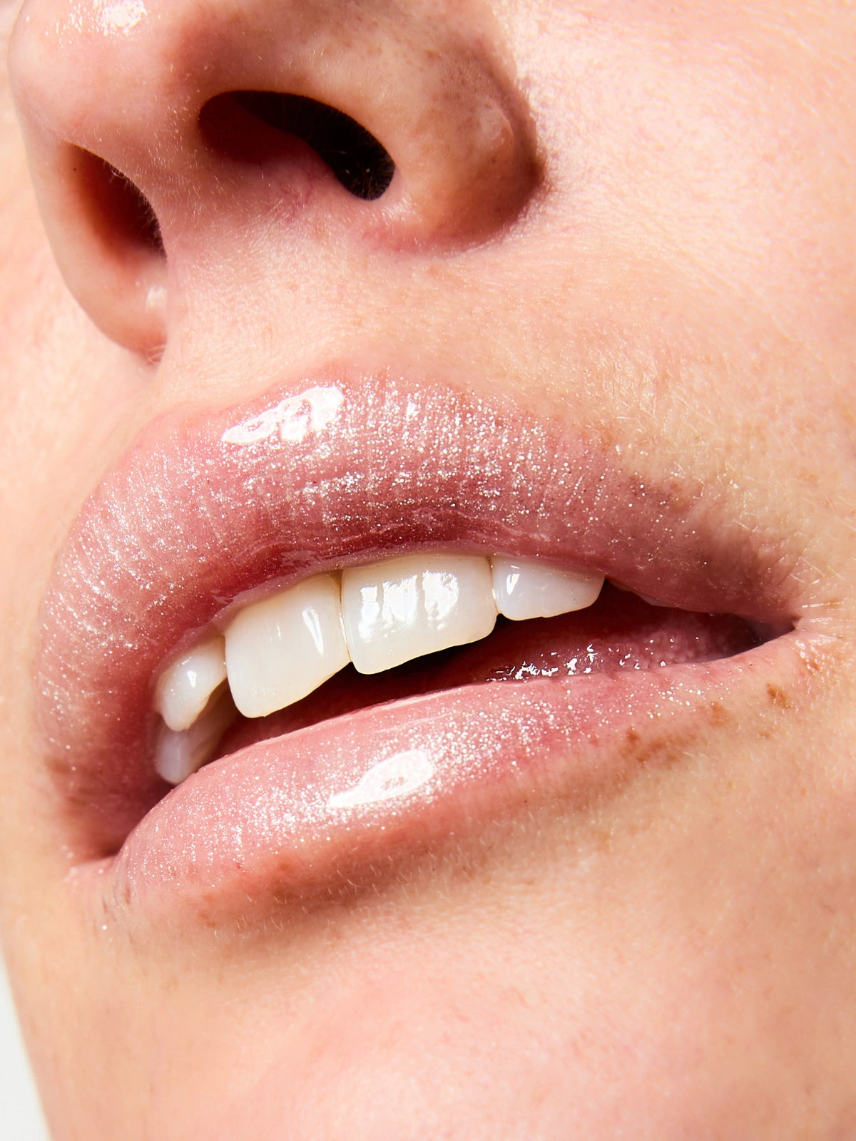 Focus sur la texture et le fini du Sérum Lèvres Repulpant SPF 30 en teinte 03. Glitter All Over sur les lèvres.