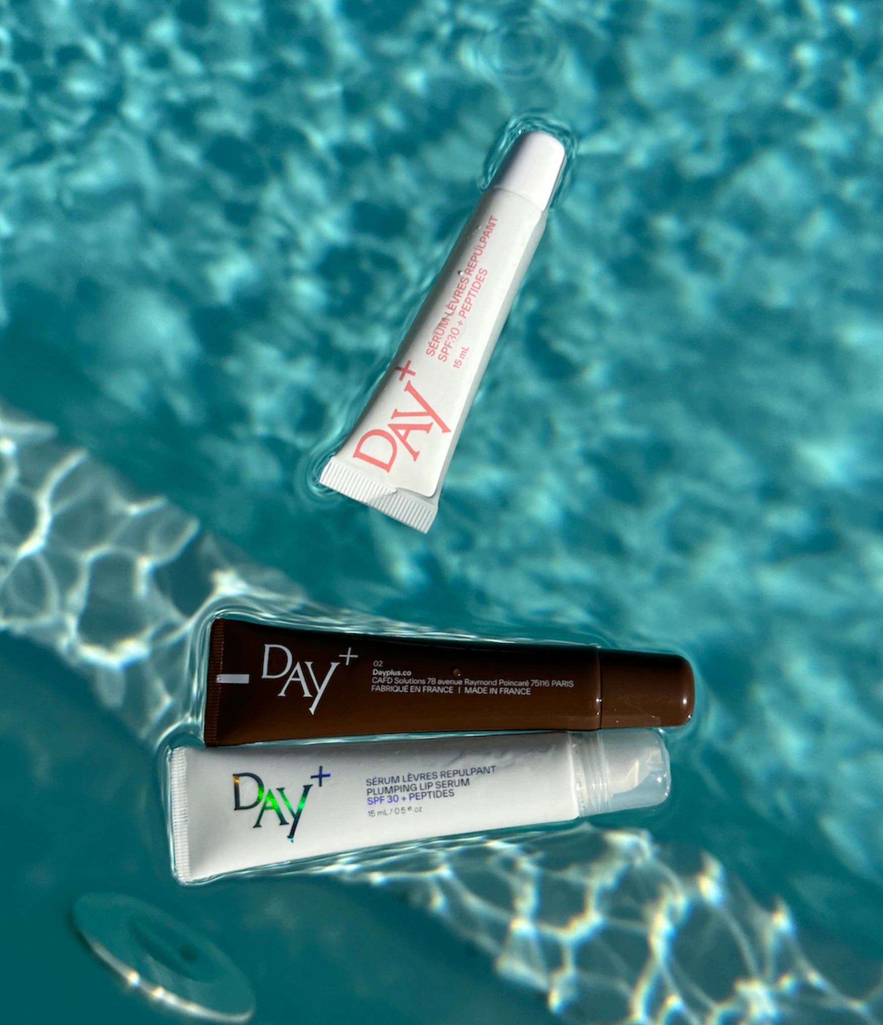 La collection de Sérums Lèvres Repulpants de chez Day+ dans une piscine.