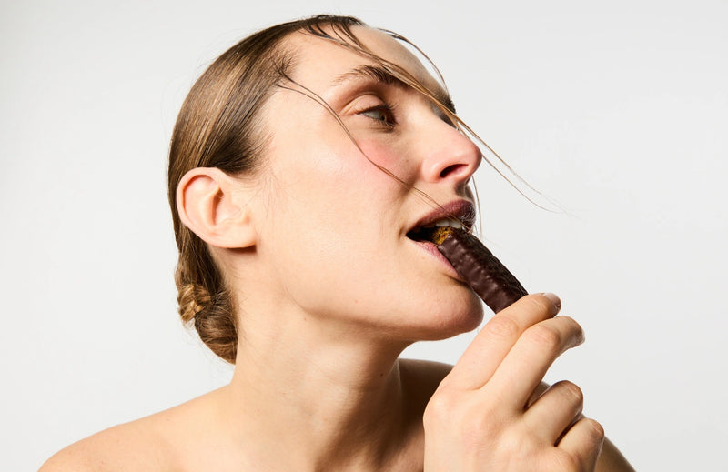 Femme mangeant la Barre Vegan Booster de Collagène de chez Day+.