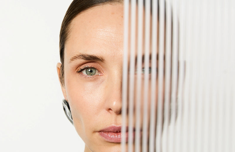 Femme avec la moitié de son visage caché par une plaque transparente avec des rayures créant un effet de vague.