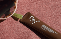 Le Sérum Lèvres chocolat posé sur une serviette de plage. 