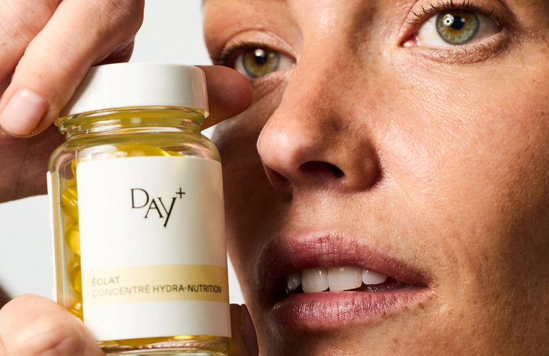 Femme tenant dans ses mains un pilulier de Soin Concentré Hydra-Nutrition.