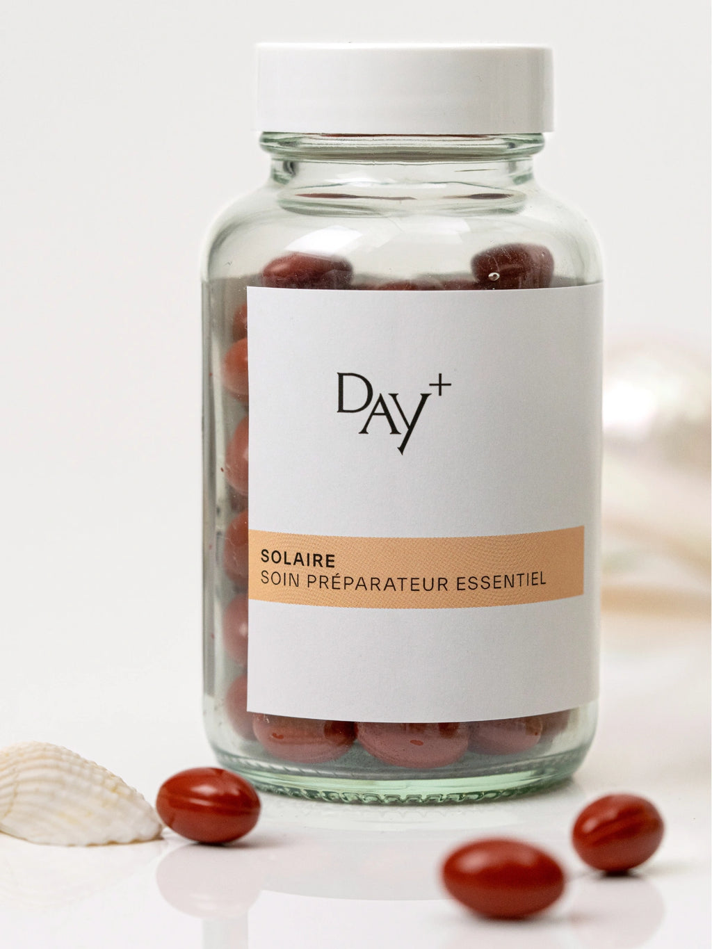 Pilulier du Soin Préparateur Essentiel avec quelques gélules rouges autour.