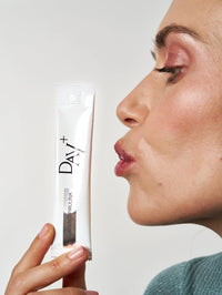 Femme embrassant un stick à boire au collagène et spiruline en édition silver.