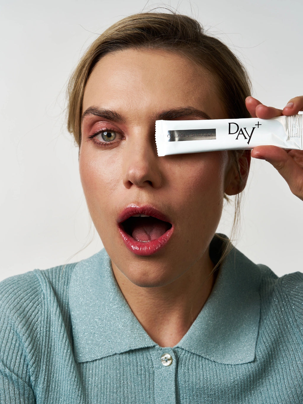 Femme tenant dans ses mains le stick à boire au collagène & spiruline en édition silver.