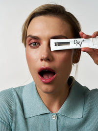 Femme tenant dans ses mains le stick à boire au collagène & spiruline en édition silver.