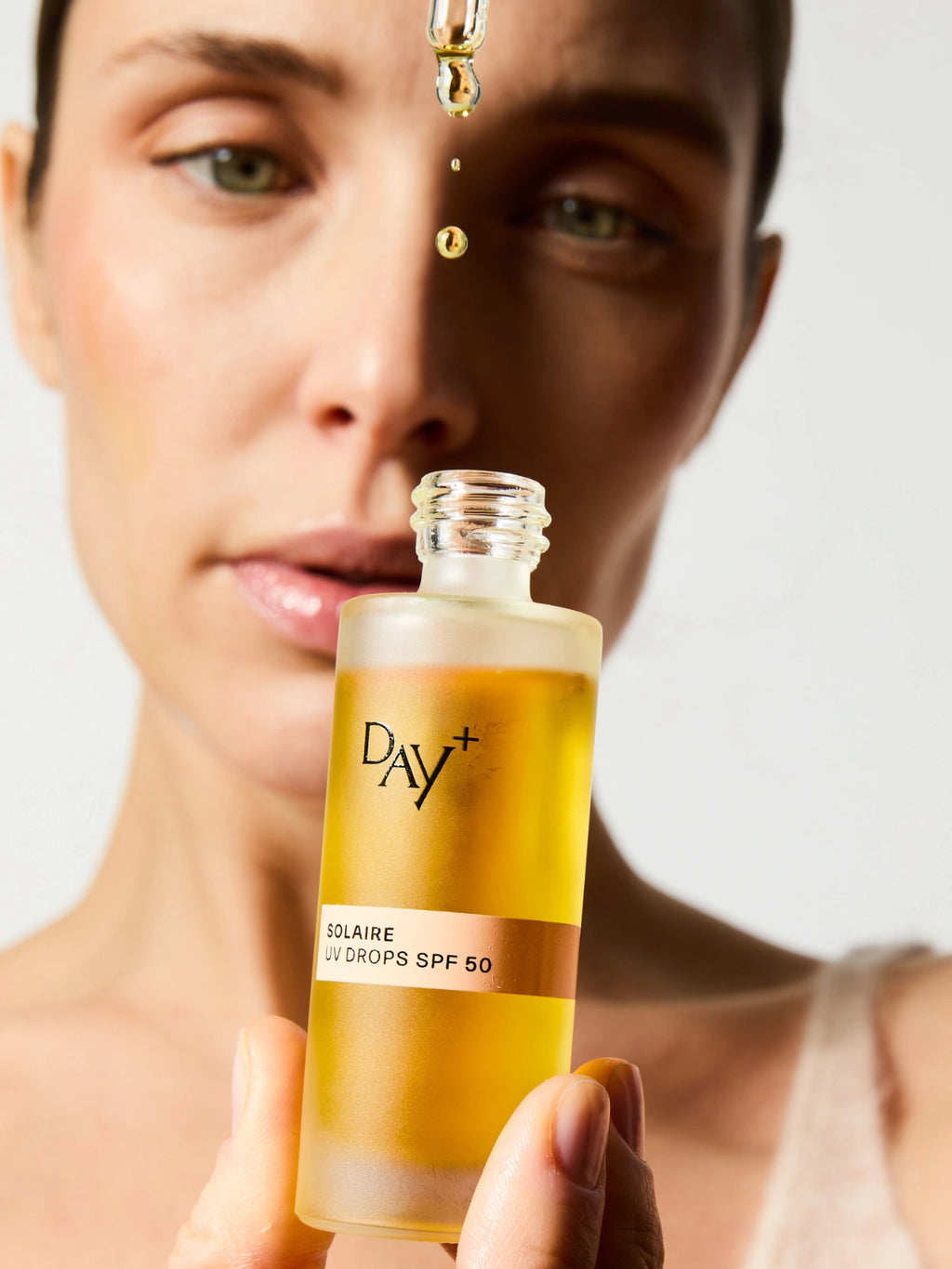 Application du sérum solaire UV Drops SPF 50.