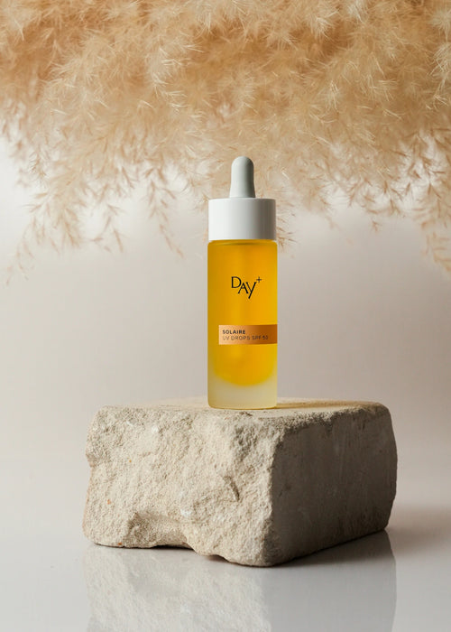 Les UV Drops SPF 50 posé sur une pierre.